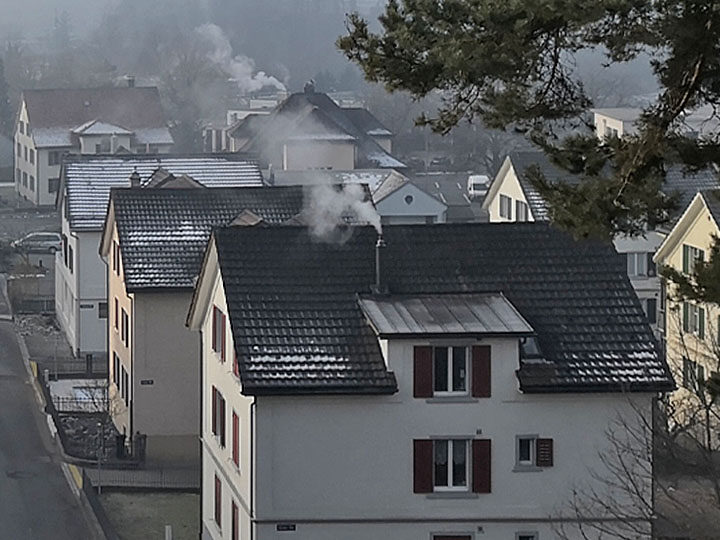 Dächer mit rauchenden Kaminen an einem Wintertag