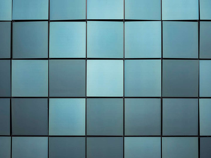 Türkisfarbenes Muster aus quadratischen Elementen, die sich teilweise an einer Kante von der Ebene abheben
