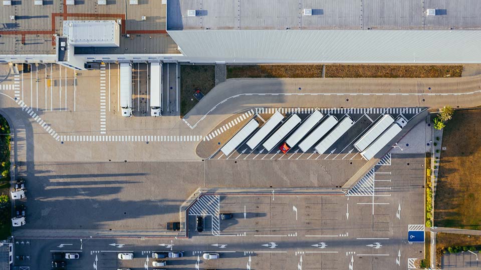 Luftaufnahme eines Logistikzenters mit parkierten Lkw
