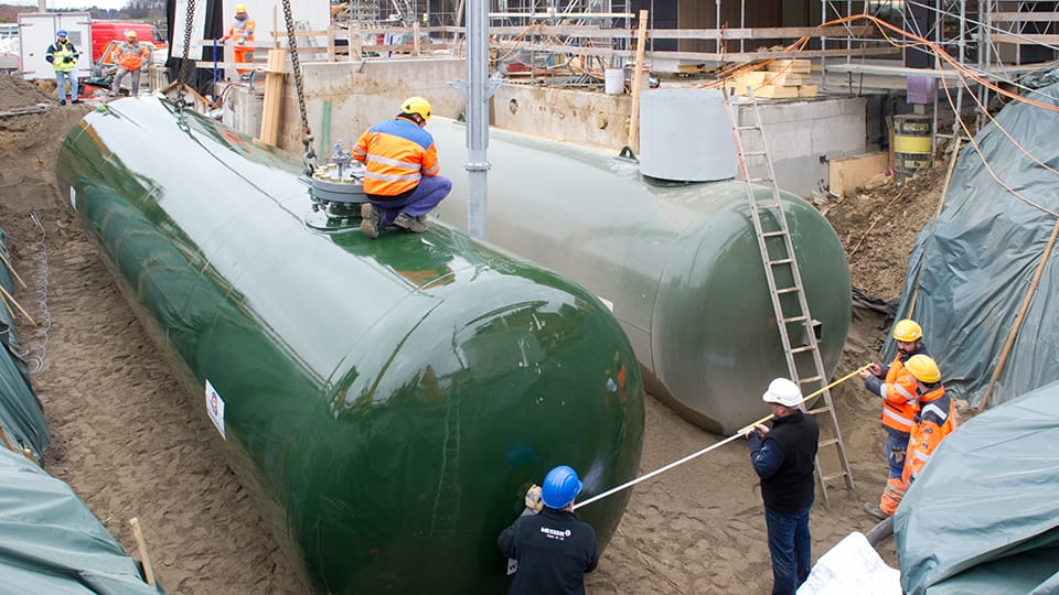 Einbau von zwei grünen Tanks auf einer Baustelle