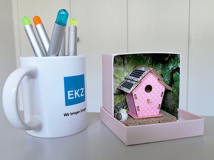 Vogelhaus-Miniaturmodell mit Solarzellen auf dem Dach – kleiner als eine Teetasse