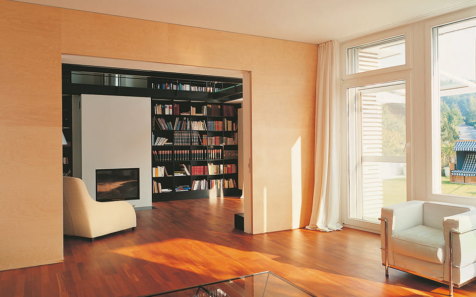 Wohnzimmer mit Durchgang zu Bibliothek - grosse Fenster, Parkett und moderne Möbel prägen das Bild
